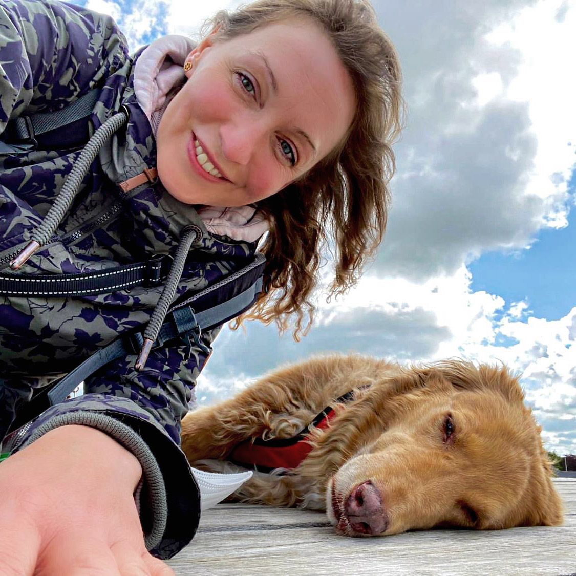 Diana Mikulla liegt gemeinsam mit ihrem Hund Louie im Freien
